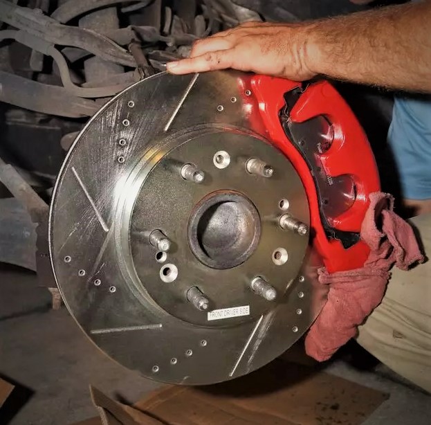 man fitting brake rotor disc on chevy silverado
