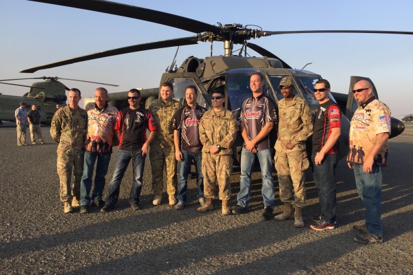 men posing near blackhawk military helicopter