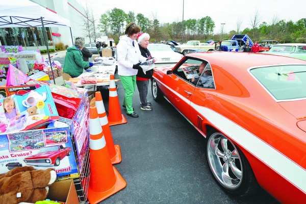 man in classic car giving toys for donation event