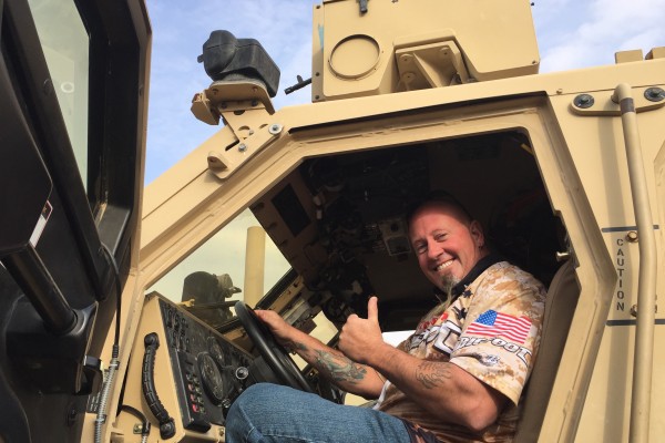 man posing in cabin of military vehicle