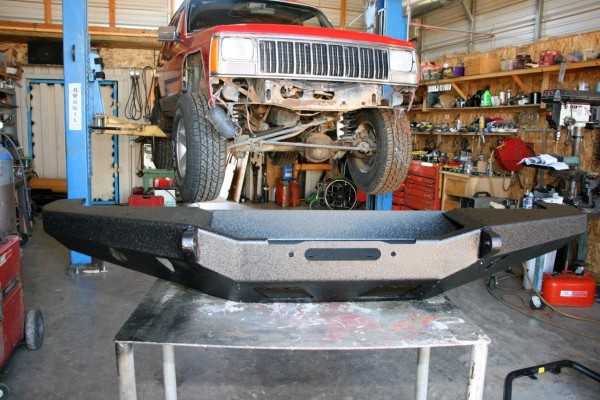 jeep cherokee on lift prior to aftermarket off road bumper install