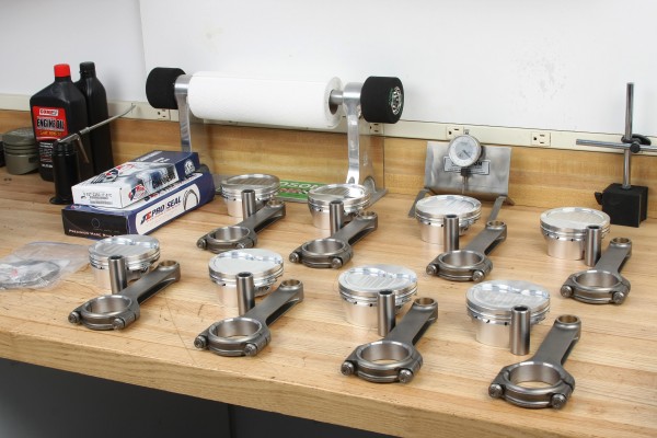 collection of piston rings and connecting rods on workbench