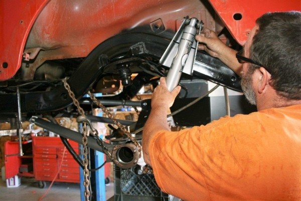 man test fitting suspension bracket on a jeep frame