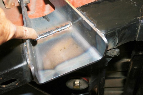 man pointing to a weld joint on a frame bracket