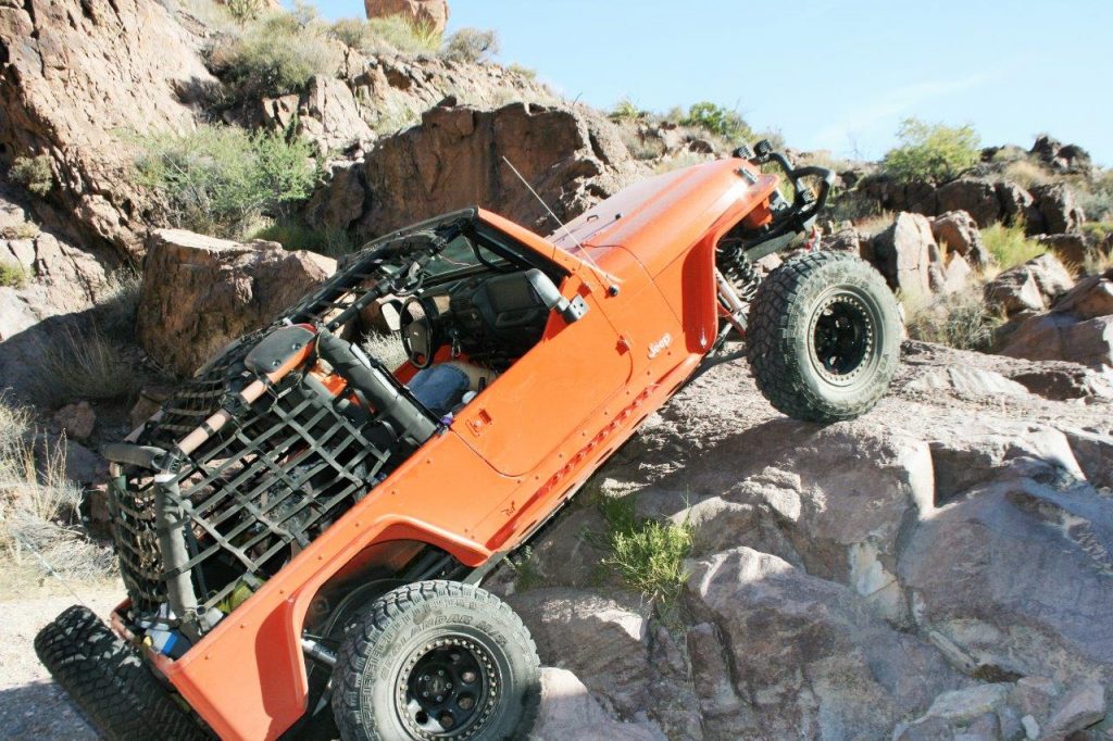 jeep wrangler lj climbing rocks on desert trail