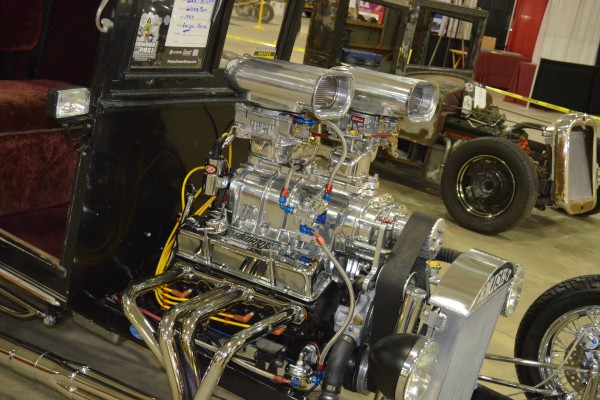 pair of superchargers atop a sbc v8 engine in a hot rod