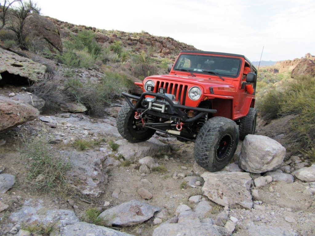 jeep tj wrangler crossing rocks on desert trail