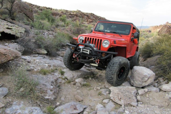 jeep tj wrangler crossing rocks on desert trail