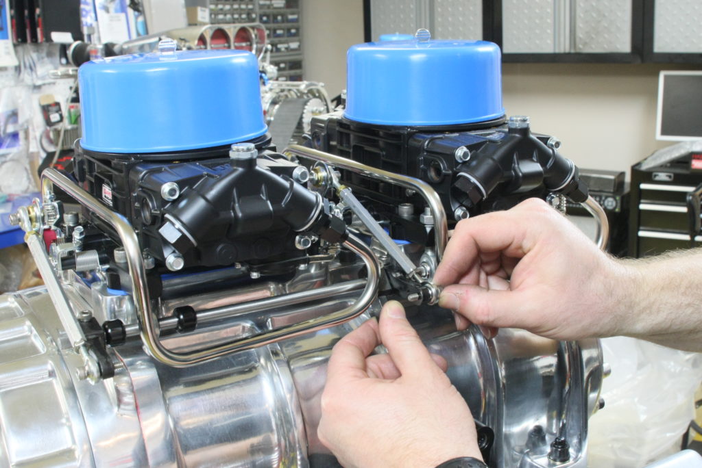 man installing dual carb linkage on supercharged engine
