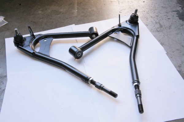 a pair of control arms on a garage floor
