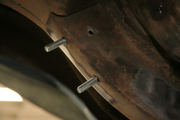 two bolts attached to a vehicle frame