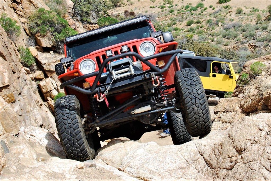 jeep wrangler tj crawling up a rocky desert trail