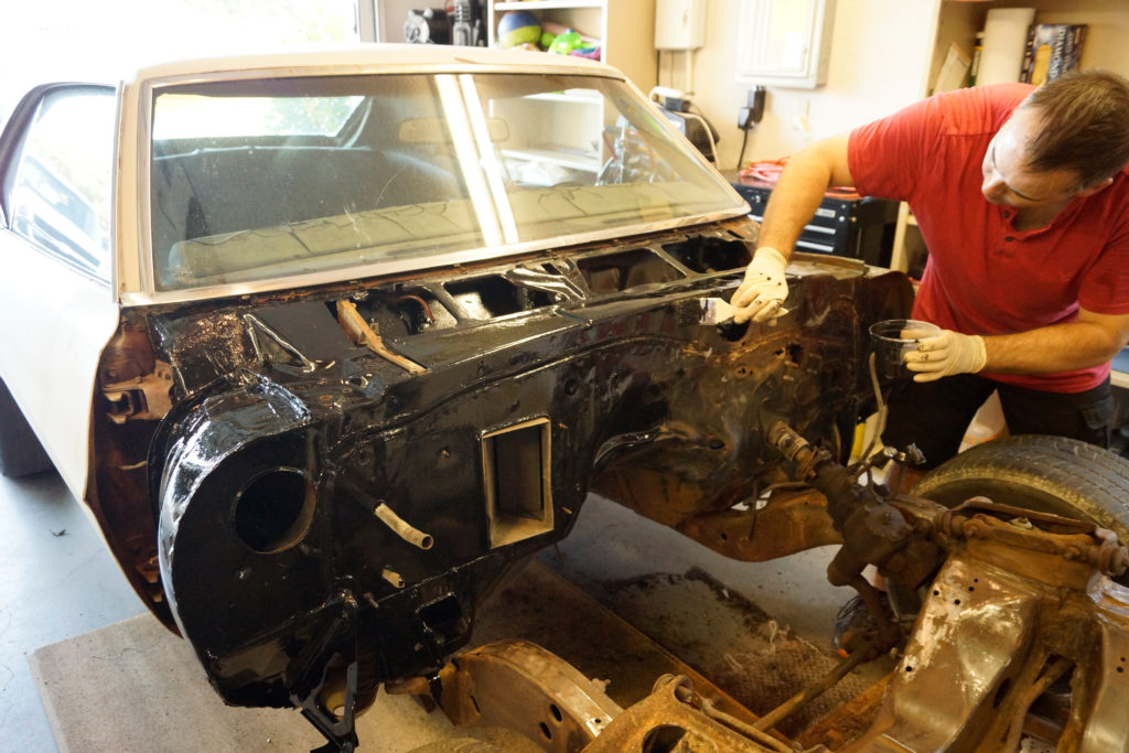 man repairing front cowl of a rust damaged 1969 pontiac firebird f-body