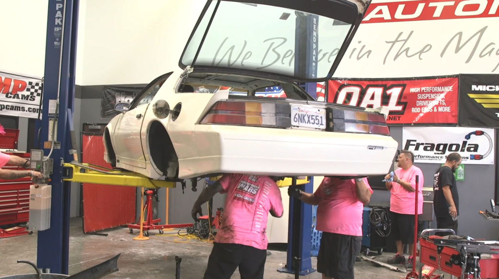 a third gen camaro on a lift getting repaired