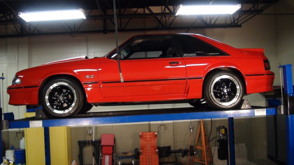 side view of a foxbody ford mustang 50 on a lift