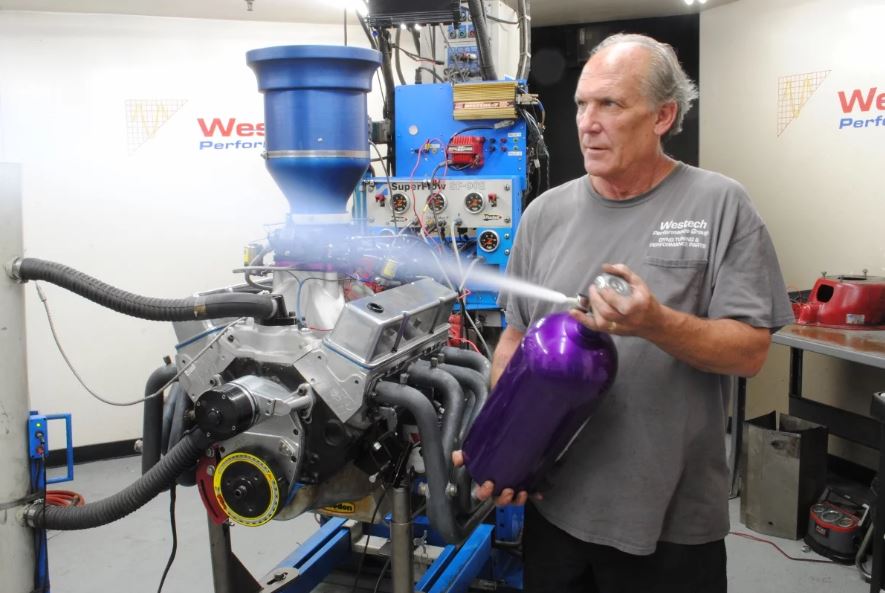 man discharging nitrous spray in engine dyno room