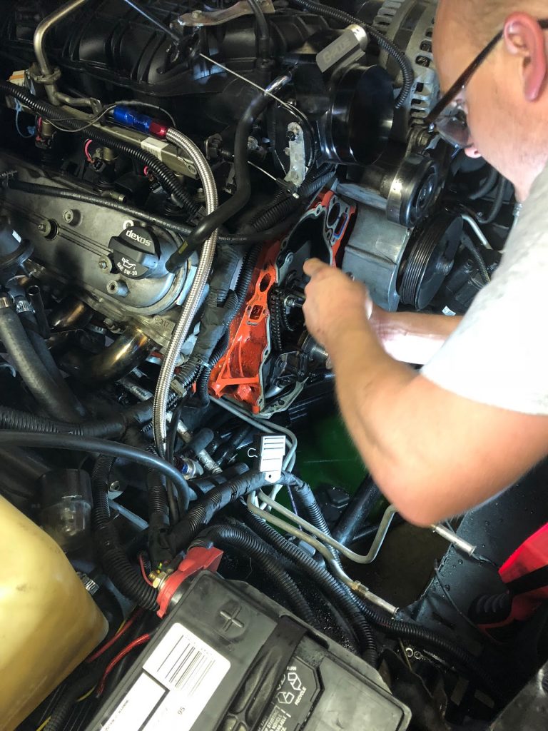 man working on front end of an ls engine