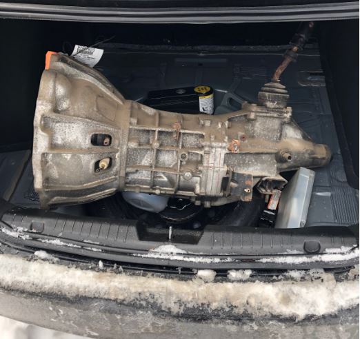 manual transmission gearbox sitting in the trunk of a car