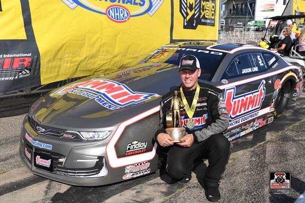 jason line poses with pro stock car and wally after winning an nhra race