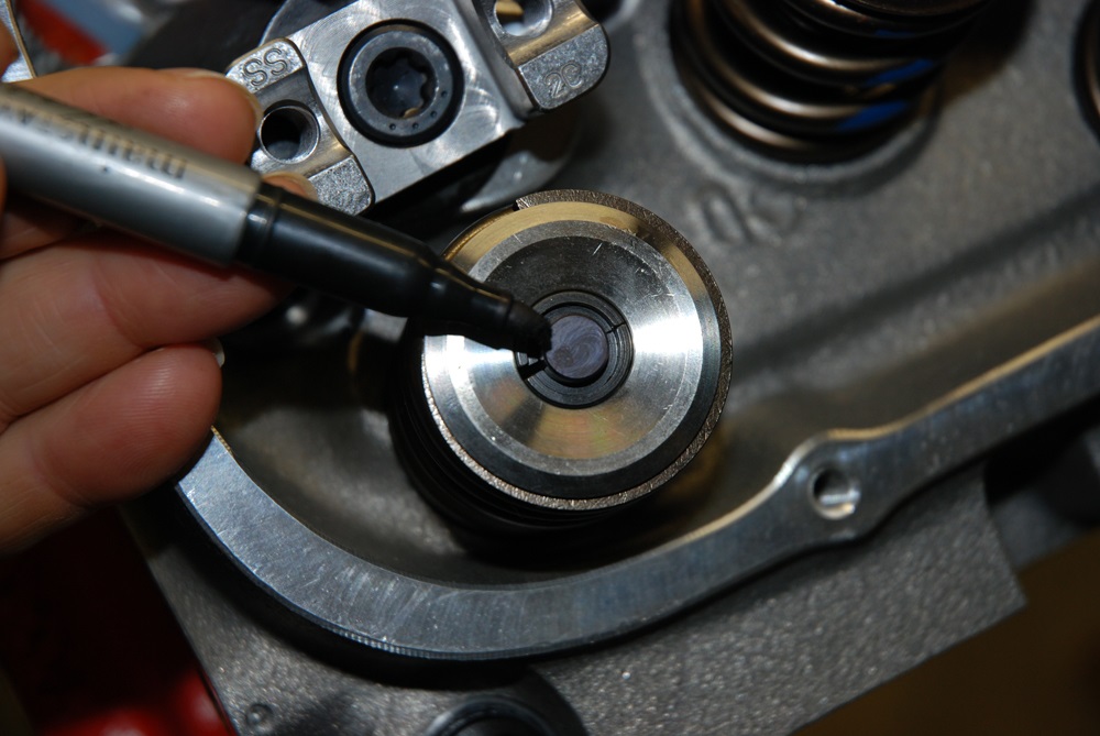 man marking valve spring with a sharpie marker