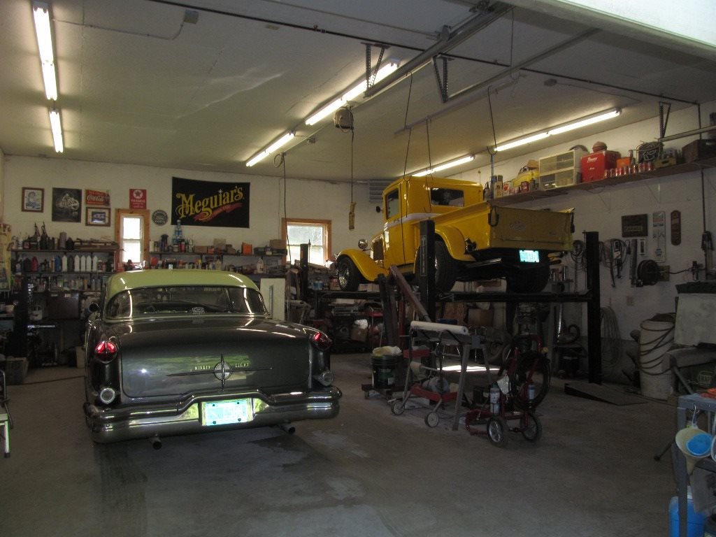 a home garage with a classic car and truck inside