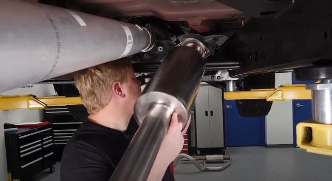 man installing borla exhaust into a ford f-150 pickup truck
