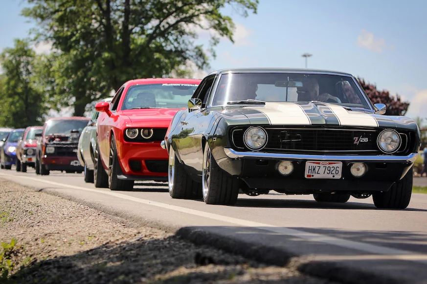 row of classic and muscle cars on street