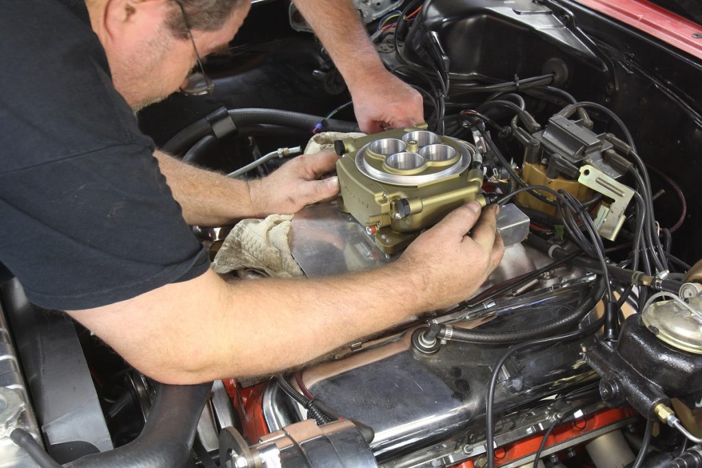 man installing throttle body fuel injection module on a big block chevy engine
