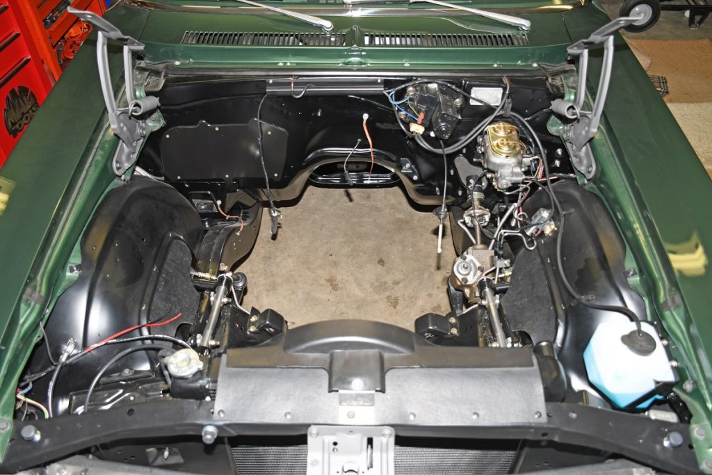 an empty engine bay of a chevy nova drag race muscle car