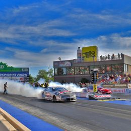 2 dragsters doing a burnout staging at track