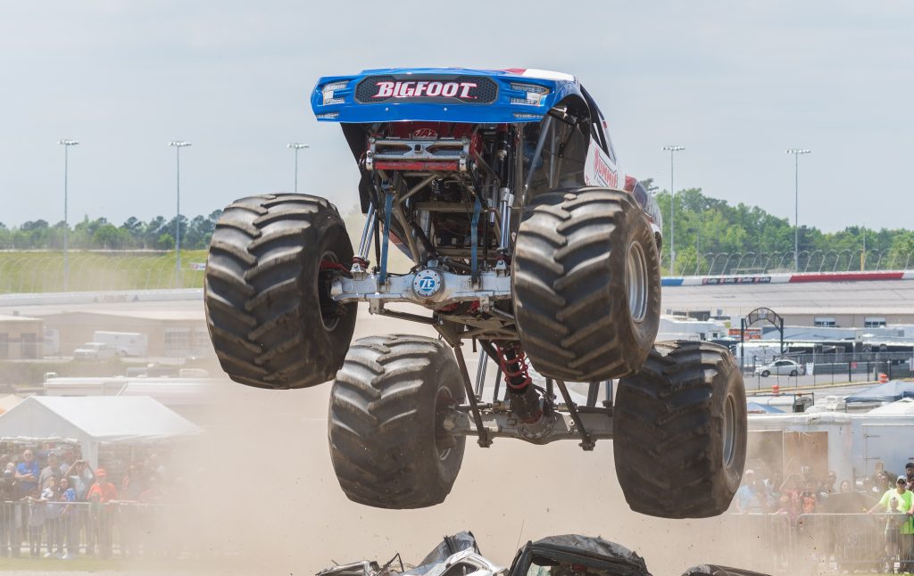 bigfoot monster truck leaping over crushed cars outside