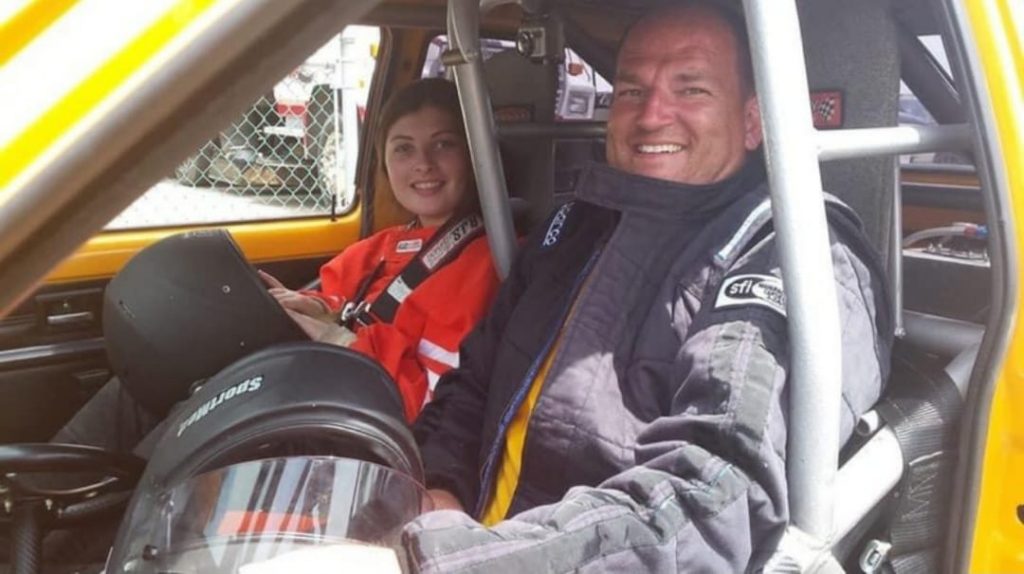 a father and daughter sitting together in a rally race car