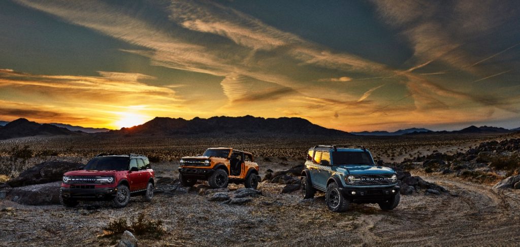 a trio of ford broncos at desert in night in press photo