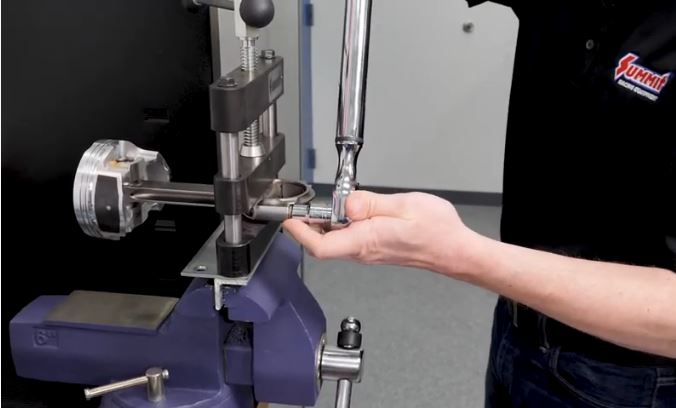 man torqueing down connecting rod bolts in torque angle demonstration