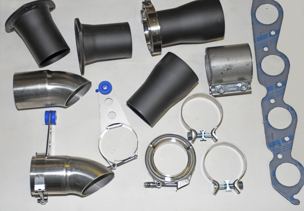 assorted collection of exhaust system connectors, hangers, tubing clamps, and parts on a table