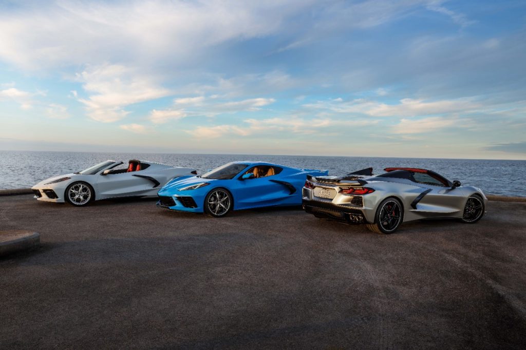 group of new chevy mid engine corvettes in front of a seascape