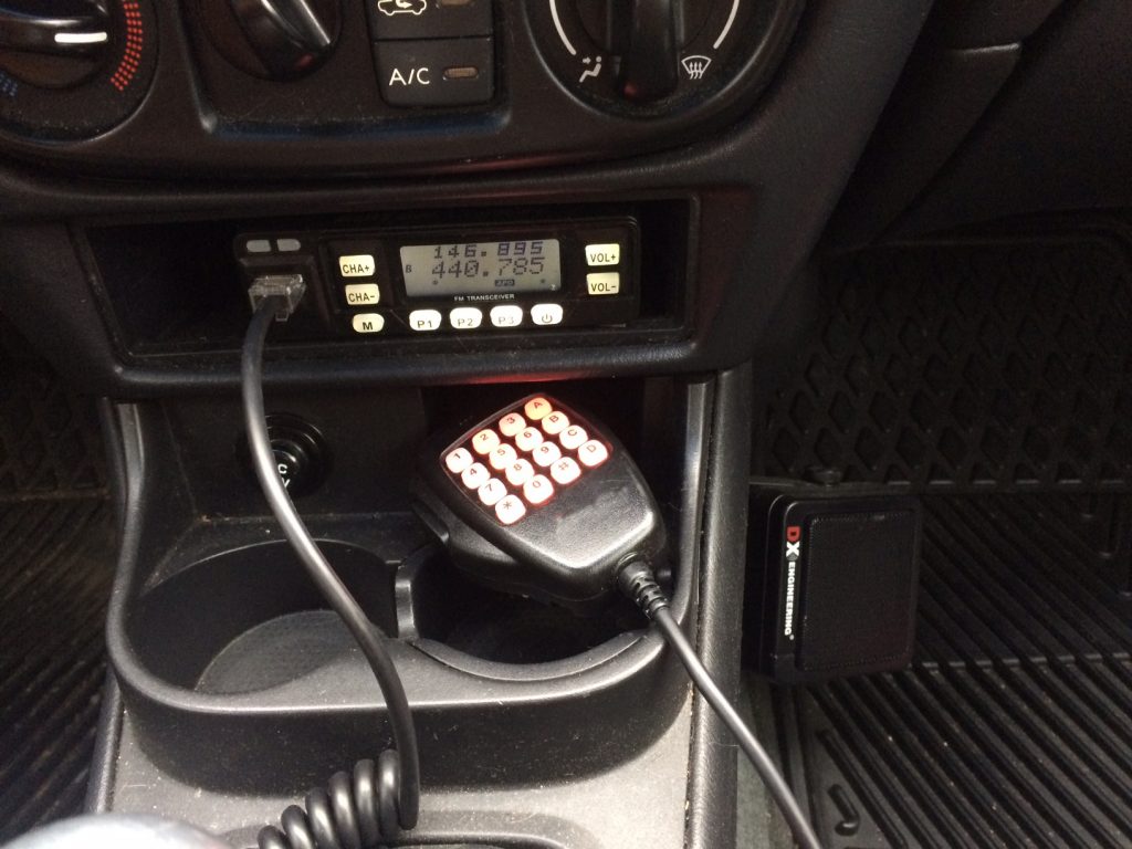 small mobile 2m 70cm uhf vhf ham radio in the dash pocket of a 2004 nissan sentra