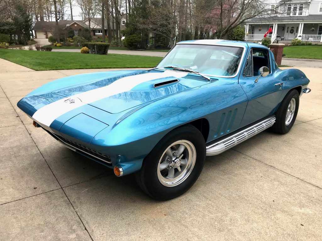 custom blue and white 1965 corvette sting ray parked in driveway