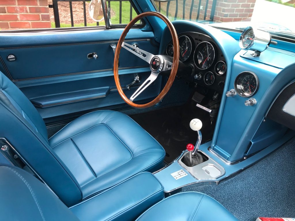 interior of a customized 1965 corvette sting ray with a hurst line lock shifter and sun tach