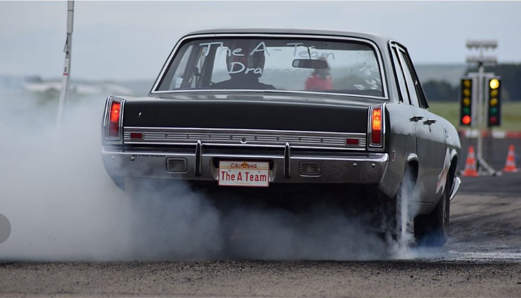 plymouth scamp drag car doing a burnout at dragstrip