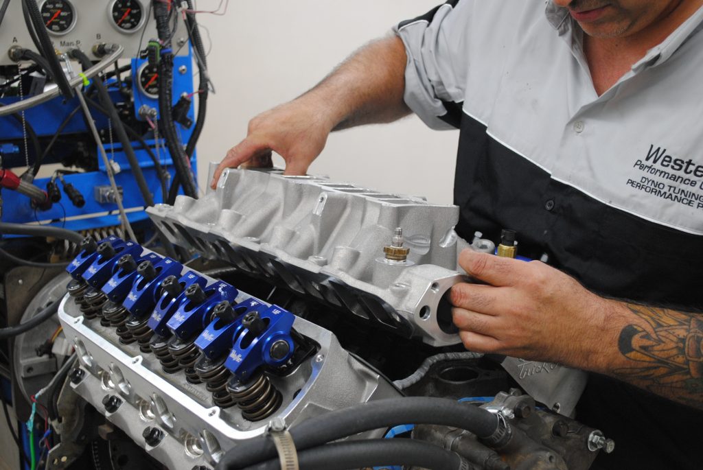 man installing intake manifold on ford 5.0 v8 enigne