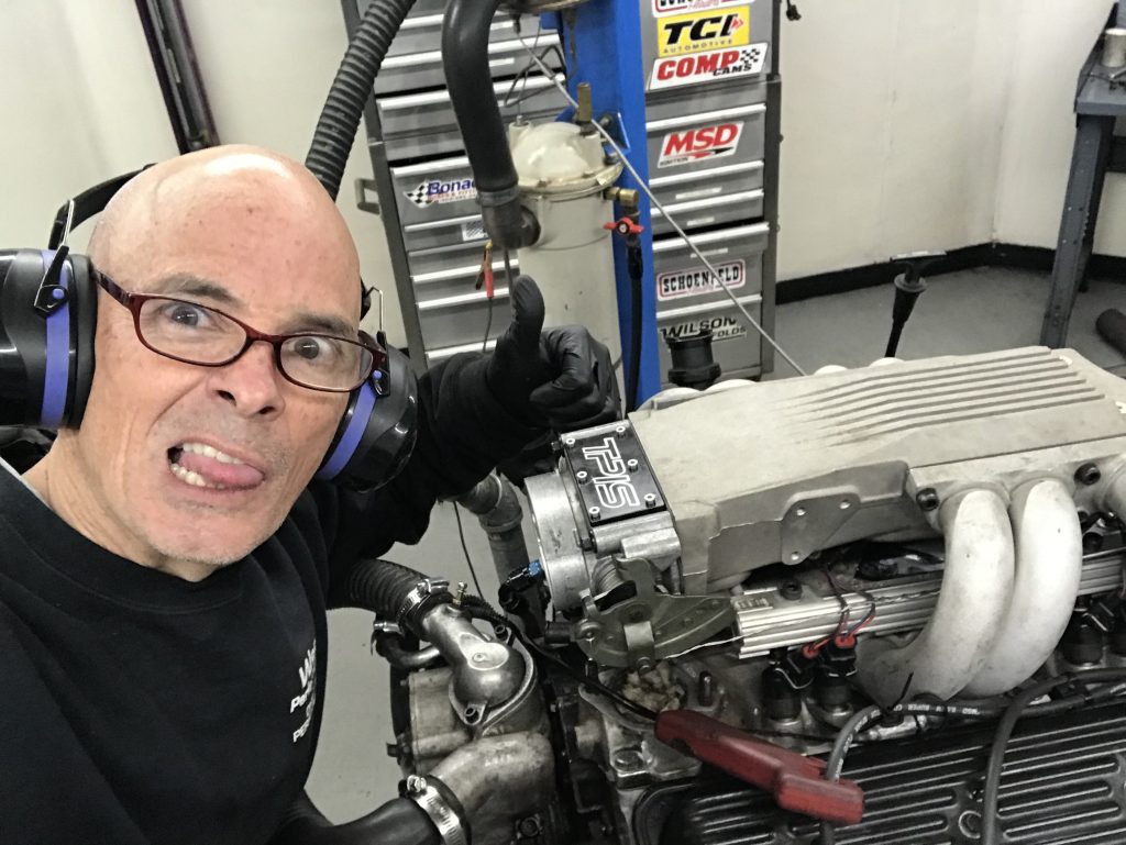 richard holdener poses with an l99 engine on a dyno