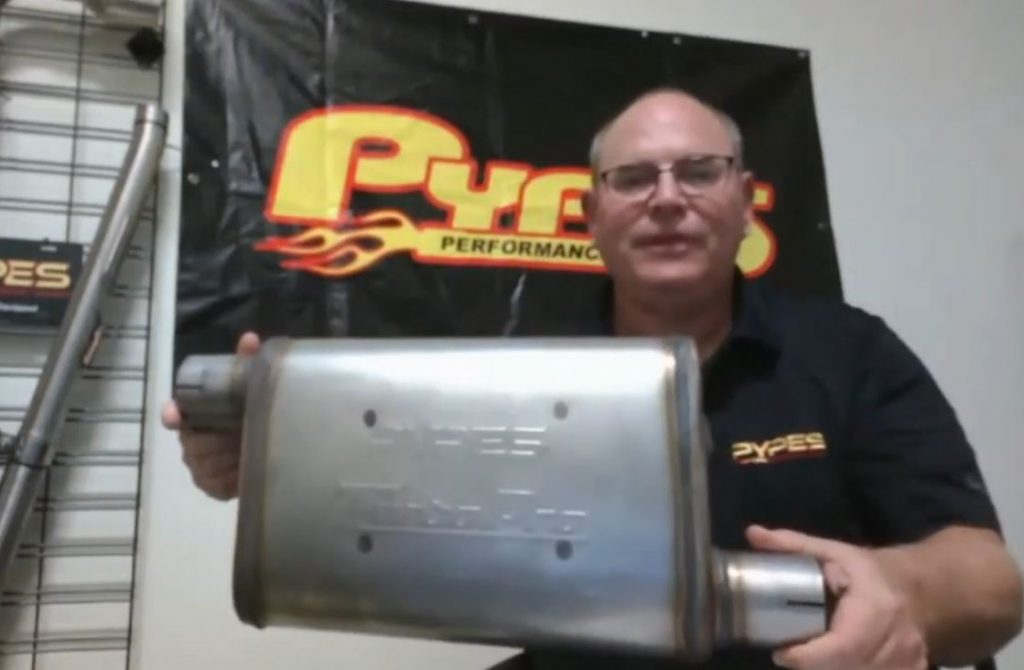 man holding pypes turbo muffler during presentation