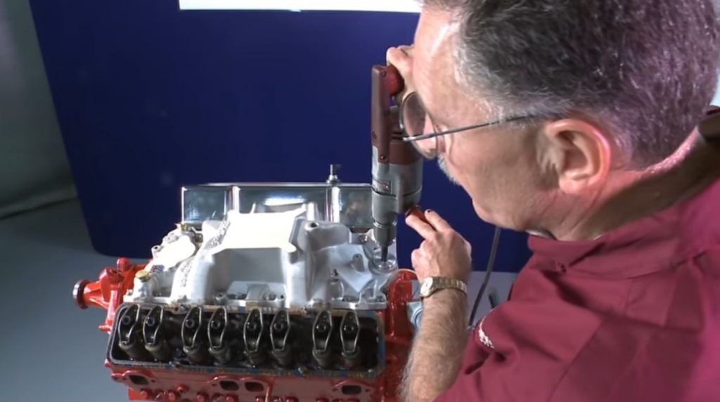 man using a melling oil pump primer to pre lube a small block chevy v8 engine