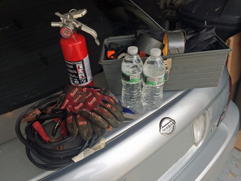 collection of emergency automotive tools on trunk of a car