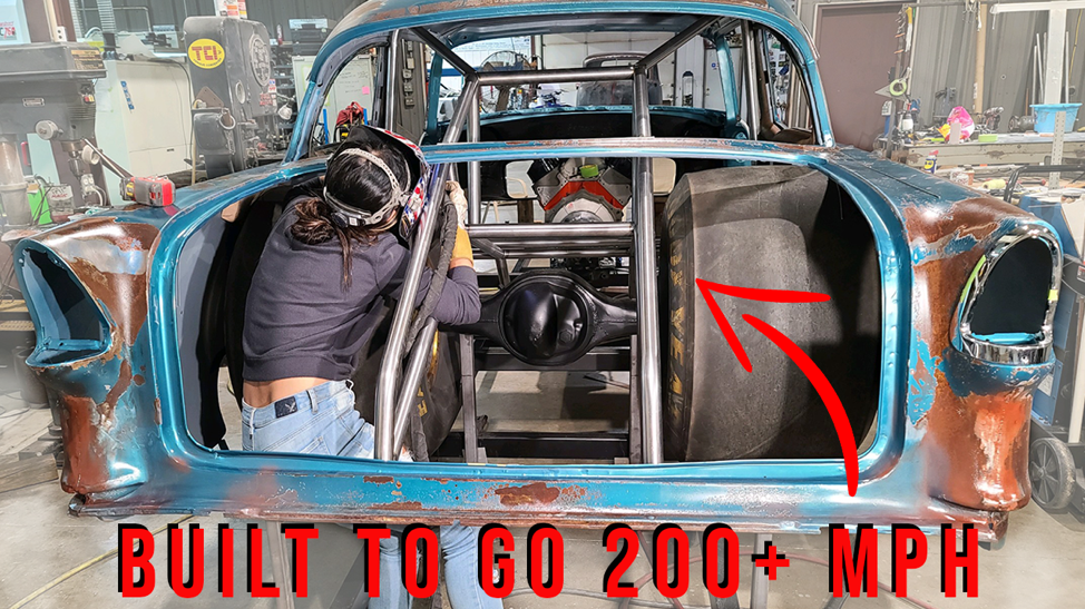 a welder sits in the trunk to weld the chassis of a 1955 chevy bel air drag race car