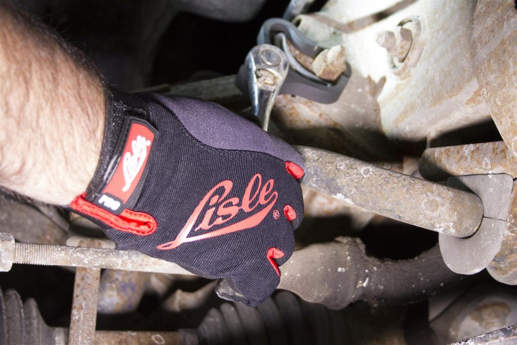 man wearing lisle mechanics gloves tightening a bracket under a car