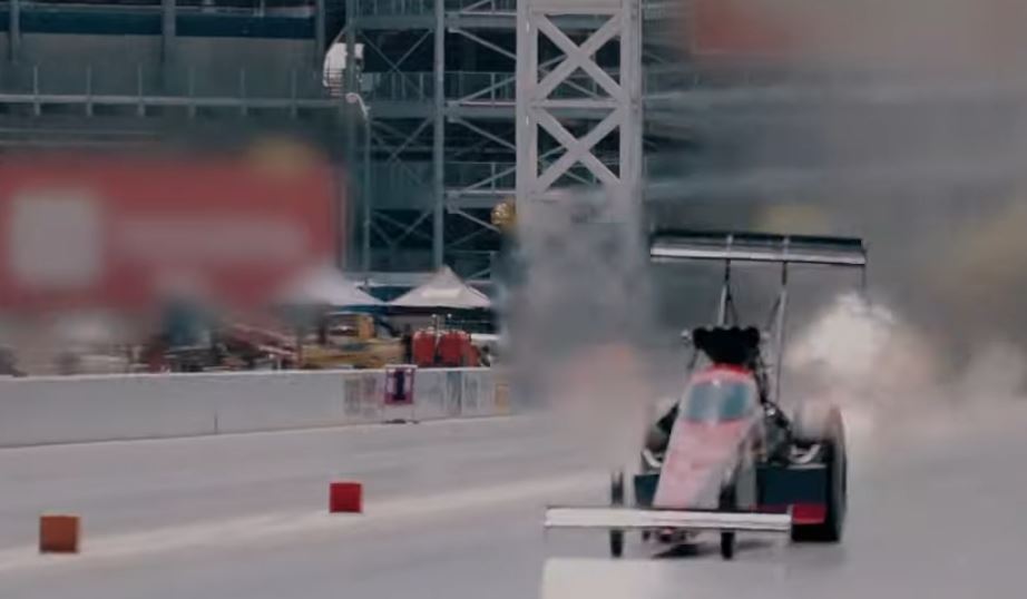 tony stewart piloting a dragster down a dragstrip race track