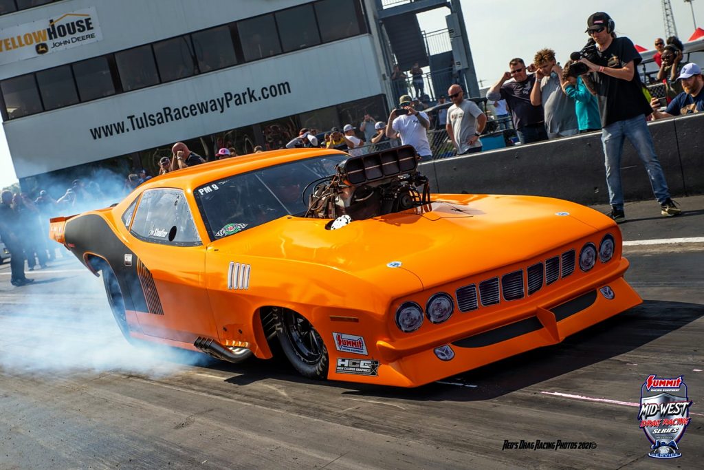 orange plymouth barracuda funny car launches at a dragstrip