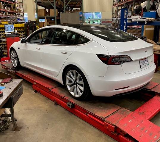 Tesla Model S getting an alignment at a shop